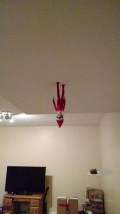 an overhead view of a living room with boxes on the floor and a red spider hanging from the ceiling