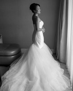 black and white photo of woman in wedding dress looking off to the side with her hand on her hip