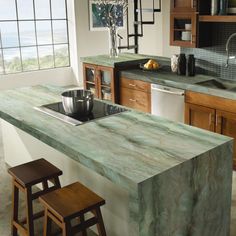 a kitchen with an island counter top and stools