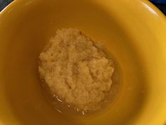 a yellow bowl filled with oatmeal sitting on top of a blue table