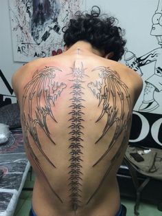 the back of a man with tattoos on his body