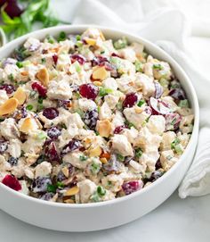 a white bowl filled with chicken salad and garnished with cranberry sauce