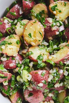 a white bowl filled with potatoes and greens