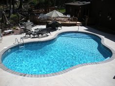 an empty swimming pool with chairs around it