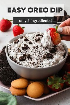 a bowl of oreo dip on a plate with cookies and strawberries