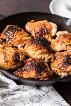 chicken thighs in a skillet ready to be cooked for the dinner guests on the table