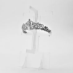 a black and white photo of a tiara on a clear display stand against a white background