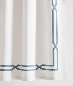 a white shower curtain with blue trim on it