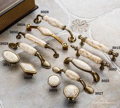 an assortment of door handles and knobs on a tile floor with measurements for each one