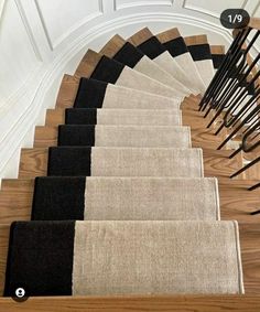 a set of stairs with black and beige rugs