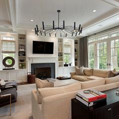 a living room filled with furniture and a flat screen tv mounted to the wall above a fireplace