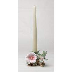 a white candle with pink flowers on it