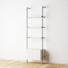 a white book shelf sitting on top of a hard wood floor next to a wall