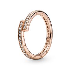 From Pandora, opt for modern minimalism with the Sparkling Overlapping Ring. Hand-finished in 14k rose gold-plated metal, this ring features an asymmetrical design where the square ends of the band slightly overlap to create 90-degree angles. The outer band features clear cubic zirconia pave framed by micro-beading, the sides have the Pandora logo and the inner shank has cut-out hearts. There are two Pandora Crown O monograms at the end of each profile. Subtly stunning on its own or show-stoppin Ring Pandora, Triple Band Ring, Pandora Logo, Pandora Rose, Rose Gold Plated Ring, Ring Hand, Pandora Style, Modern Minimalism, Pandora Bracelets