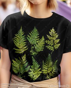 This fern leaves t-shirt is perfect for the fern lover to wear at a social gathering, on a hike, or even just as an everyday outfit. It is a great gift for anyone who spends their time enjoying nature's outdoor activities, plant nurseries, and botanical gardens. With a timeless inspired original design, this graphic tee will remain stylish for countless years to come. FABRIC CONTENT:  - Fabric content varies based on color. Solid colors are 100% cotton, heather colors are 52% cotton/48% polyeste Green Graphic Tee With Plant Print, Green Graphic Tee With Plants Print, Botanical Style Green T-shirt With Graphic Print, Botanical Graphic Print Green Tops, Green Botanical T-shirt With Graphic Print, Botanical Green T-shirt With Graphic Print, Green Botanical Graphic Print Tops, Green Short Sleeve Tops With Plant Print, Green Tops With Plant Print Short Sleeves