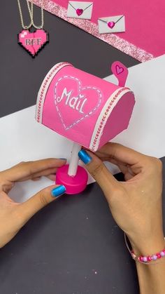 someone is making a valentine's day card out of a pink mailbox with hearts on it