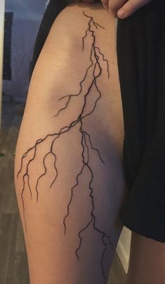 a woman's thigh with a lightning bolt tattoo on it