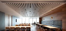 an empty room with tables and chairs in front of a wall that is made out of wood