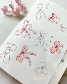 some pink bows are sitting on top of a piece of paper