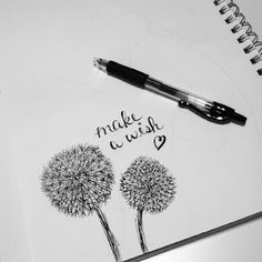 a notepad with a dandelion drawn on it and a pen next to it