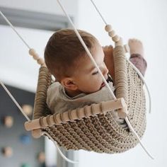 a small child is sitting in a hammock