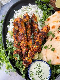 chicken skewers, rice and cilantro on a plate