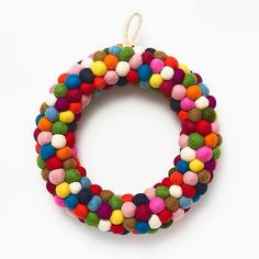 a multicolored beaded bracelet on a white background with a string hanging from it