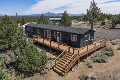 an aerial view of a tiny house in the woods with stairs leading up to it