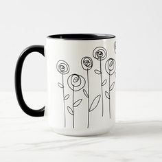 a black and white coffee mug with flowers on it