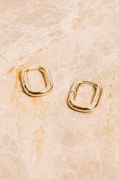 "Sleek and shiny with their high polish finish, these minimal rectangular huggie hoop earrings will elevate your everyday look! Dimensions: 1\" x 3/4\" Materials: Alloy, 18k Gold Plating Ships in a branded jewelry pouch and box, perfect for gift giving!" Ear Jacket Earring Gold, 70s Earrings, Gold Huggie Hoop Earrings, Gold Ear Jacket, Ear Jacket Earring, Earring Jackets, Vegan Handbags, Huggie Hoop Earrings, Fringe Earrings