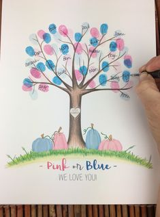 a person is drawing a family tree with blue, pink and orange leaves on it