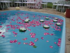 pink and white flowers floating on the water in a swimming pool at a wedding reception