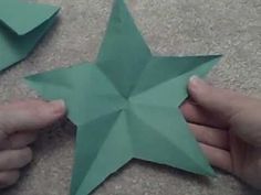 two hands are holding origami stars on the floor