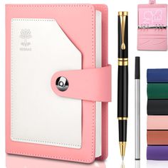 a pink notebook with pen and notepad next to it