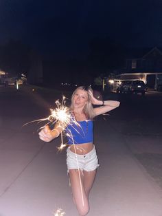 a woman is holding sparklers in her hands