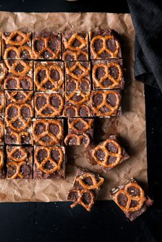 chocolate and pretzels are arranged on brown paper