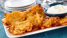 some fried food on a white plate with dip