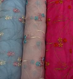 three different colored fabrics with flowers on them, one is pink and the other is blue