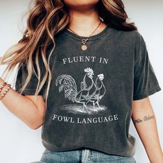 a woman wearing a t - shirt that says fluent in fowl language