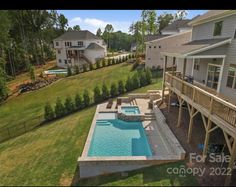 an aerial view of a backyard with a swimming pool and hot tub in the middle