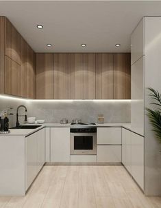 a modern kitchen with white cabinets and wood flooring