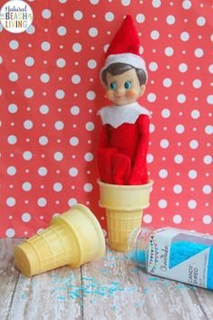 an elf sitting on top of a ice cream cone next to a tube of toothpaste