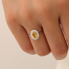 a woman's hand with a yellow and white diamond ring