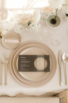 a table setting with place settings and flowers