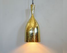 a gold colored light hanging from a wall