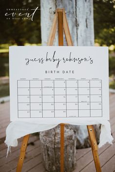 a wooden easel holding a sign that says guess baby robinson's birth date