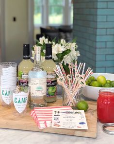 bottles of alcohol sitting on top of a wooden cutting board