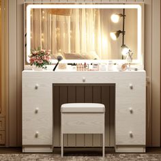 a white vanity with lights on it and a stool in front of the mirror that is lit up