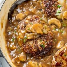 meat and mushroom stew in a skillet with a ladle on the side, ready to be eaten