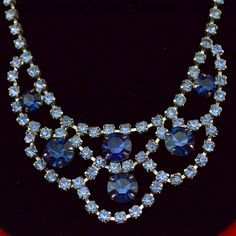 "Vintage Beautiful Iridescent Blue Rhinestone Costume Jewelry Necklace & Clip-on Earring Set This is a lovely matching costume necklace or choker and clip-on earrings set featuring sparkling blue Aurora Borealis crystals. The lovely large dark blue stones are surrounded by light blue loops. The necklace has an added clear stone extender. The clip on earrings have one large dark blue stone and two smaller ones and three light blue stones (one stone missing), one has five clustered light blue ston Blue Round Necklaces For Evening, Royal Blue Crystal Jewelry For Party, Elegant Blue Rhinestone Necklace For Wedding, Blue Crystal Rhinestone Necklace For Wedding, Blue Jeweled Evening Jewelry, Blue Jeweled Party Jewelry, Blue Crystal Jewelry With Rhinestones, Blue Sparkling Crystal Jewelry, Blue Costume Jewelry Necklaces For Wedding